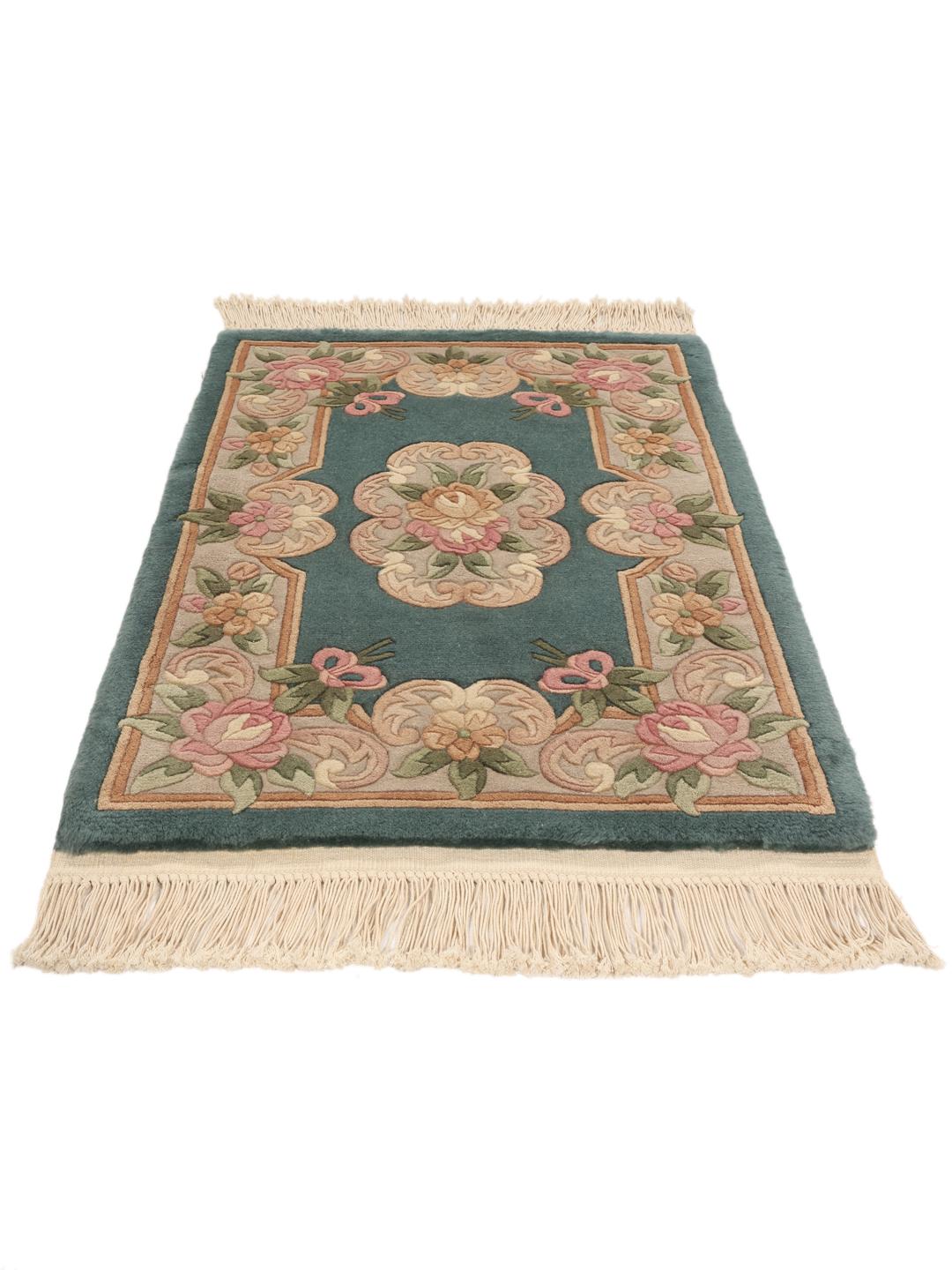 Et rektangulært kinesisk tæppe med blomstermønstre i nuancer af teal, lyserød og beige.