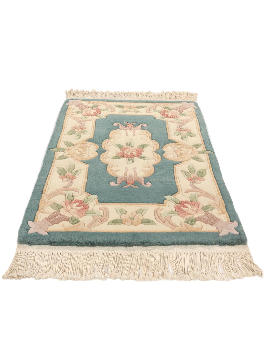 Et håndknyttet kinesisk tæppe med blomstermotiver i teal og beige.
