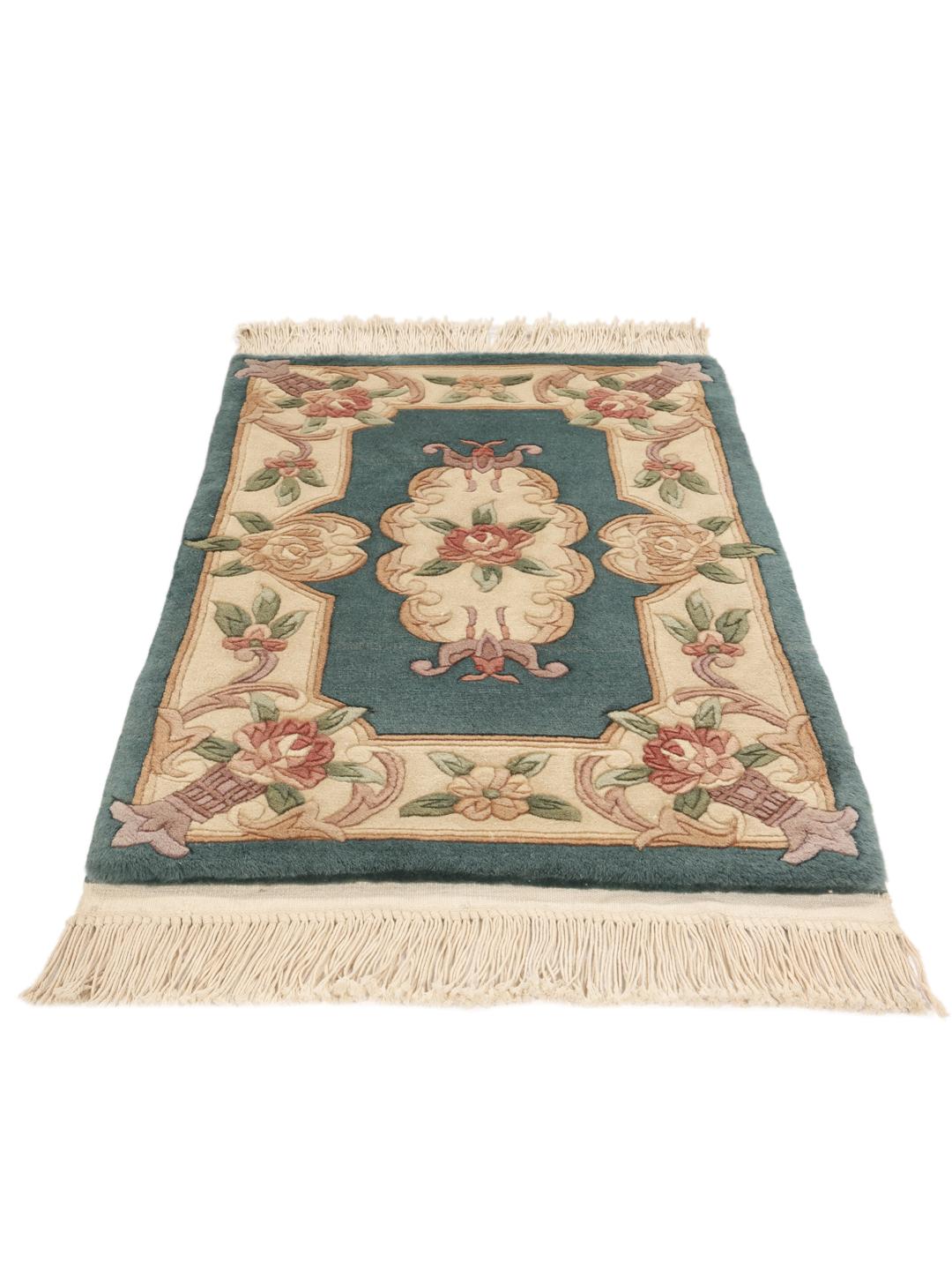 Et håndknyttet kinesisk tæppe med blomstermotiver i teal og beige.