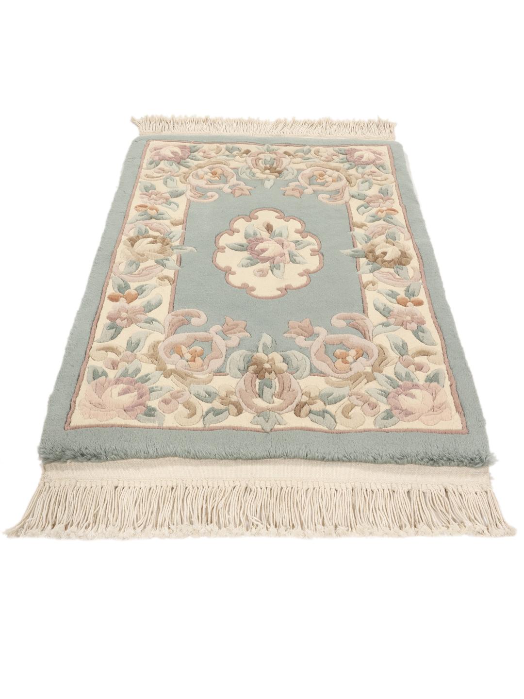 Håndknyttet kinesisk tæppe med et blomstret mønster i blåt og beige.