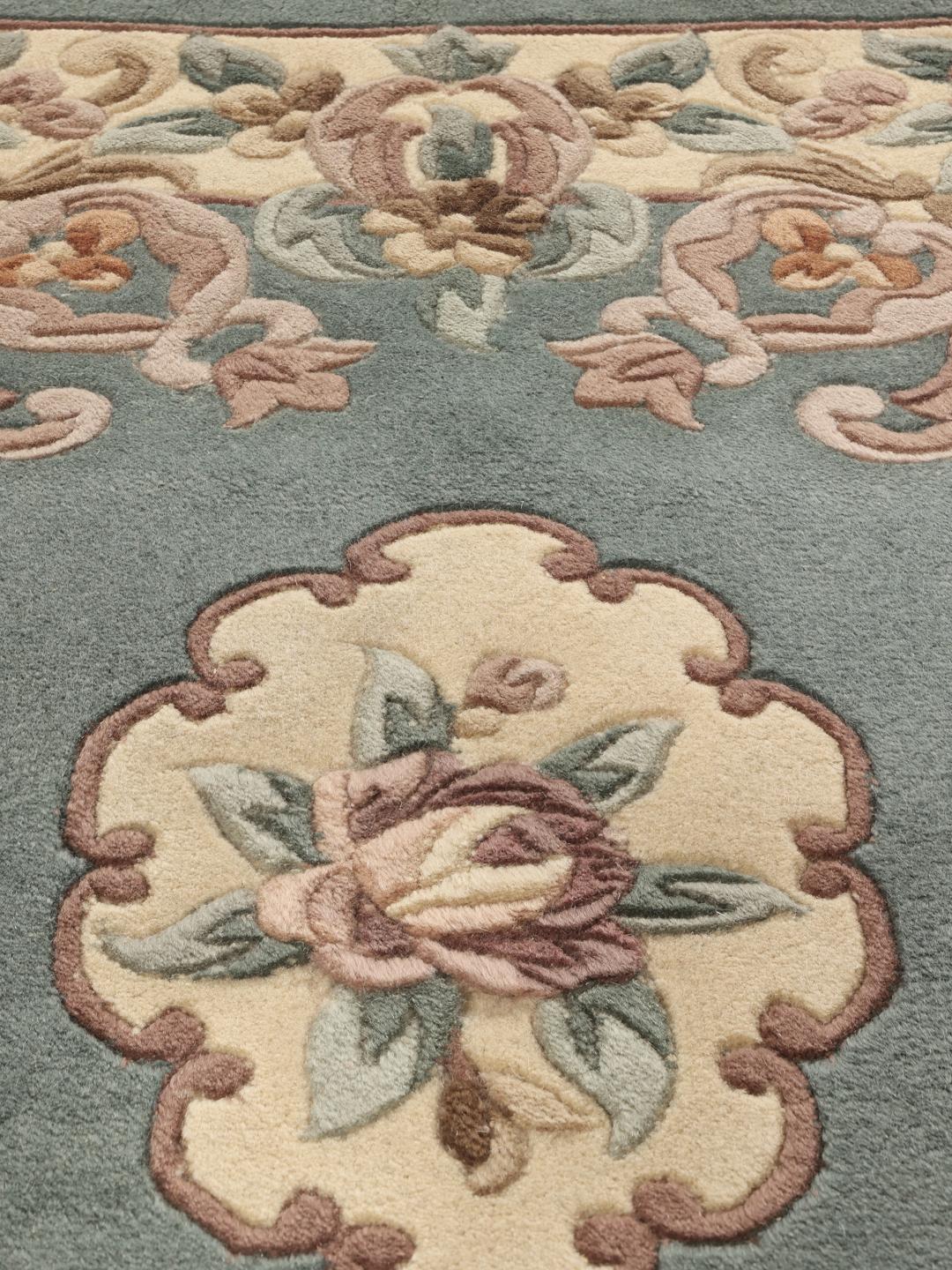 Håndknyttet kinesisk tæppe med et blomstret mønster i blåt og beige.