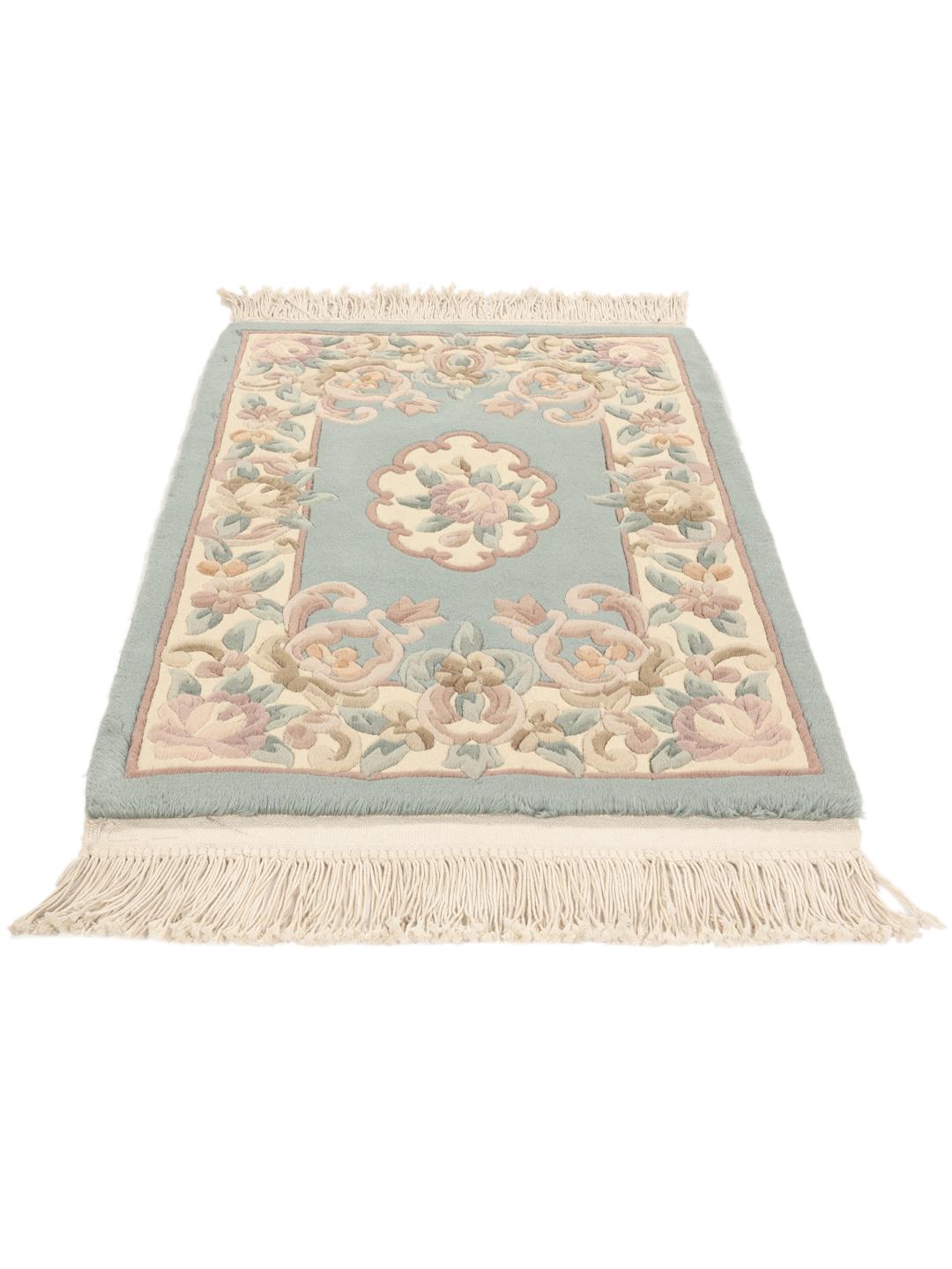 Håndknyttet kinesisk tæppe med blomstermotiver i lyseblå og beige.