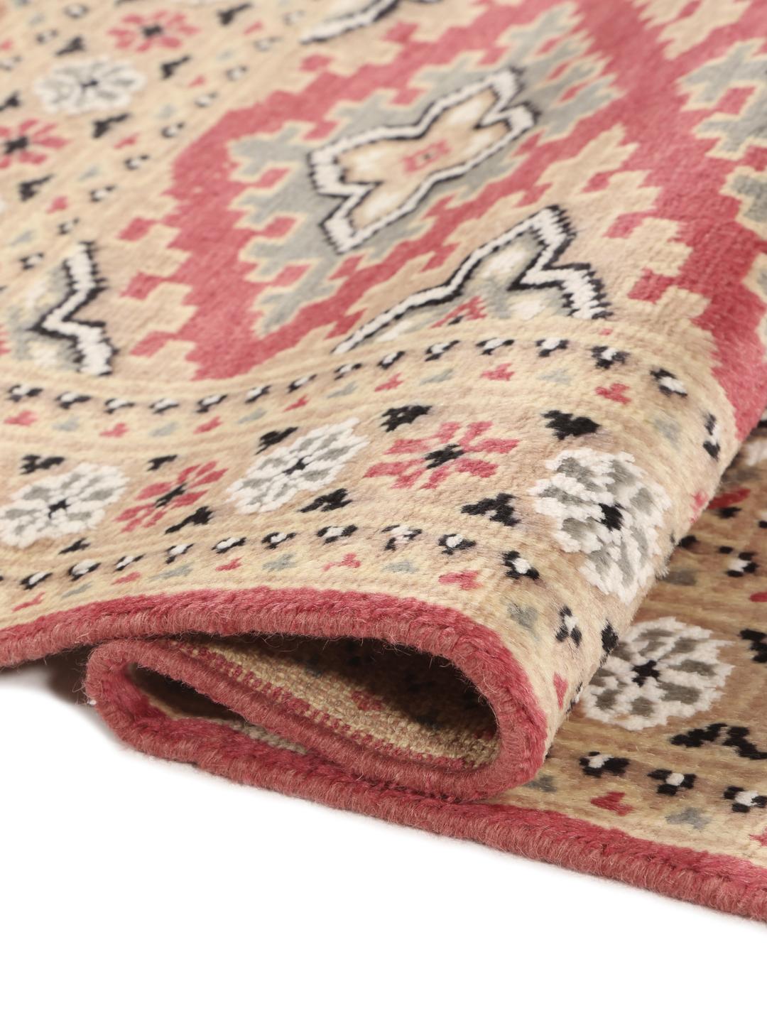 Hand-knotted Pakistan Bokhara rug featuring red and beige geometric patterns.