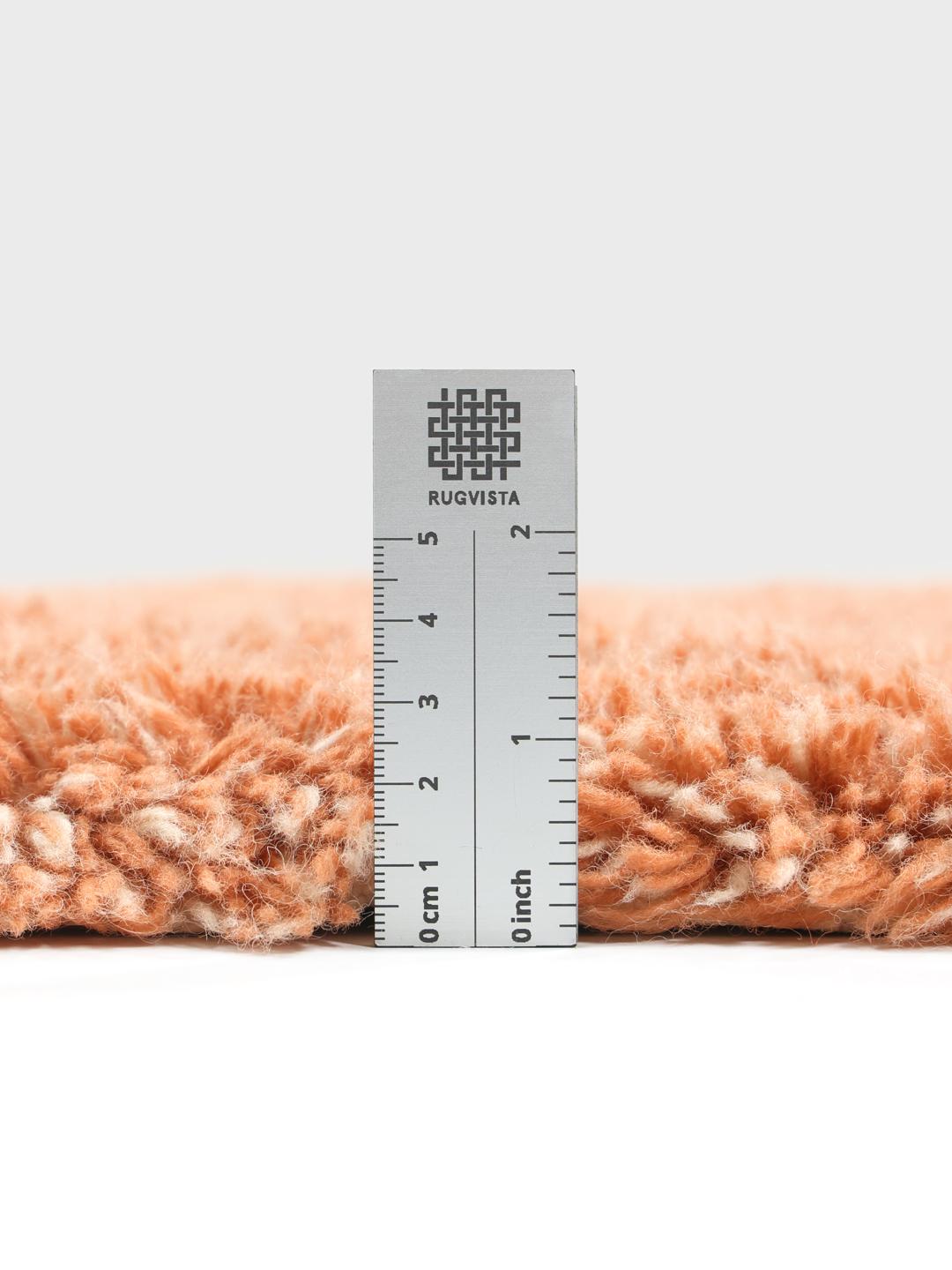 Een zacht terracotta shaggy kleed met franjes