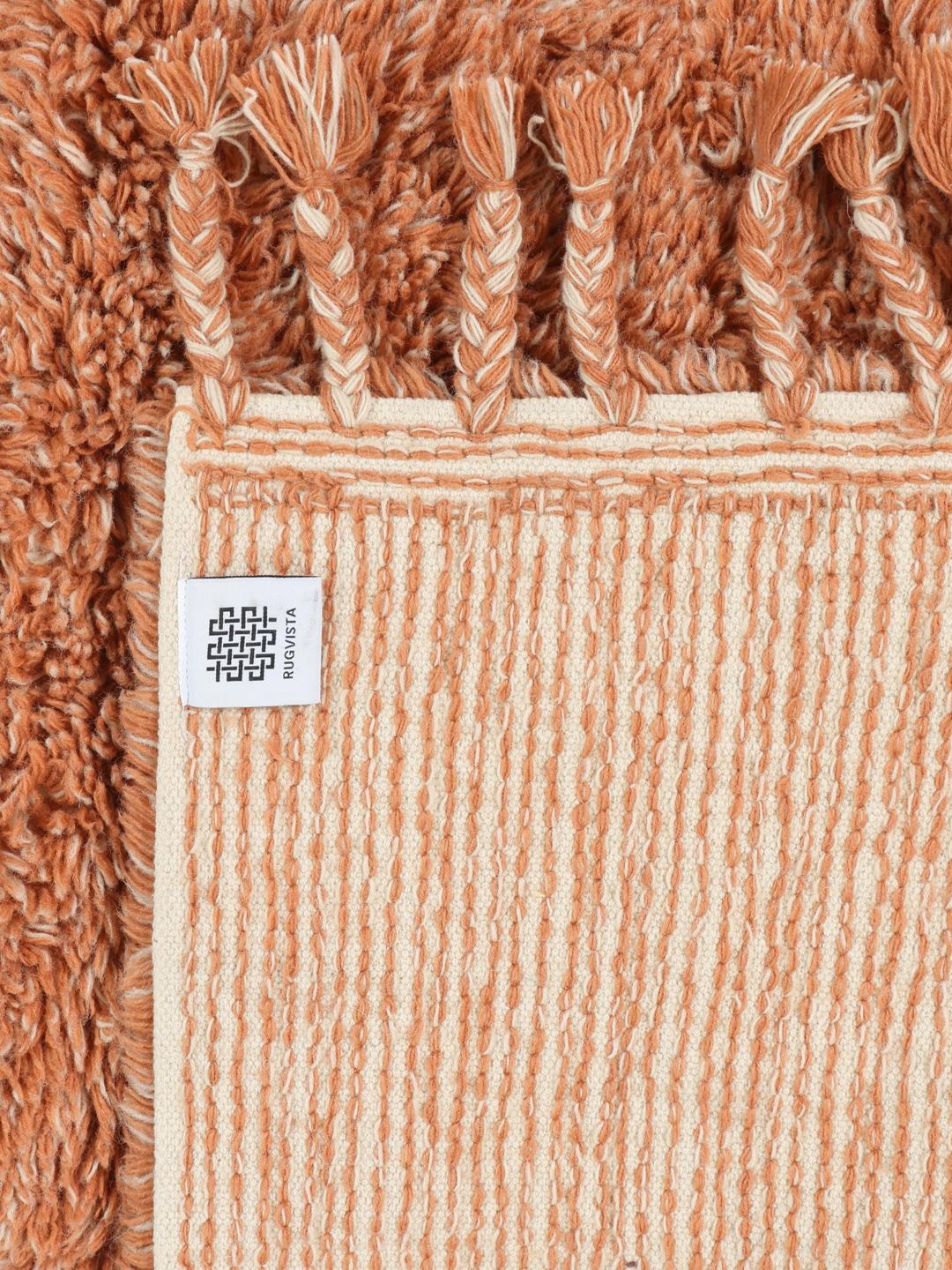 Een zacht terracotta shaggy kleed met franjes