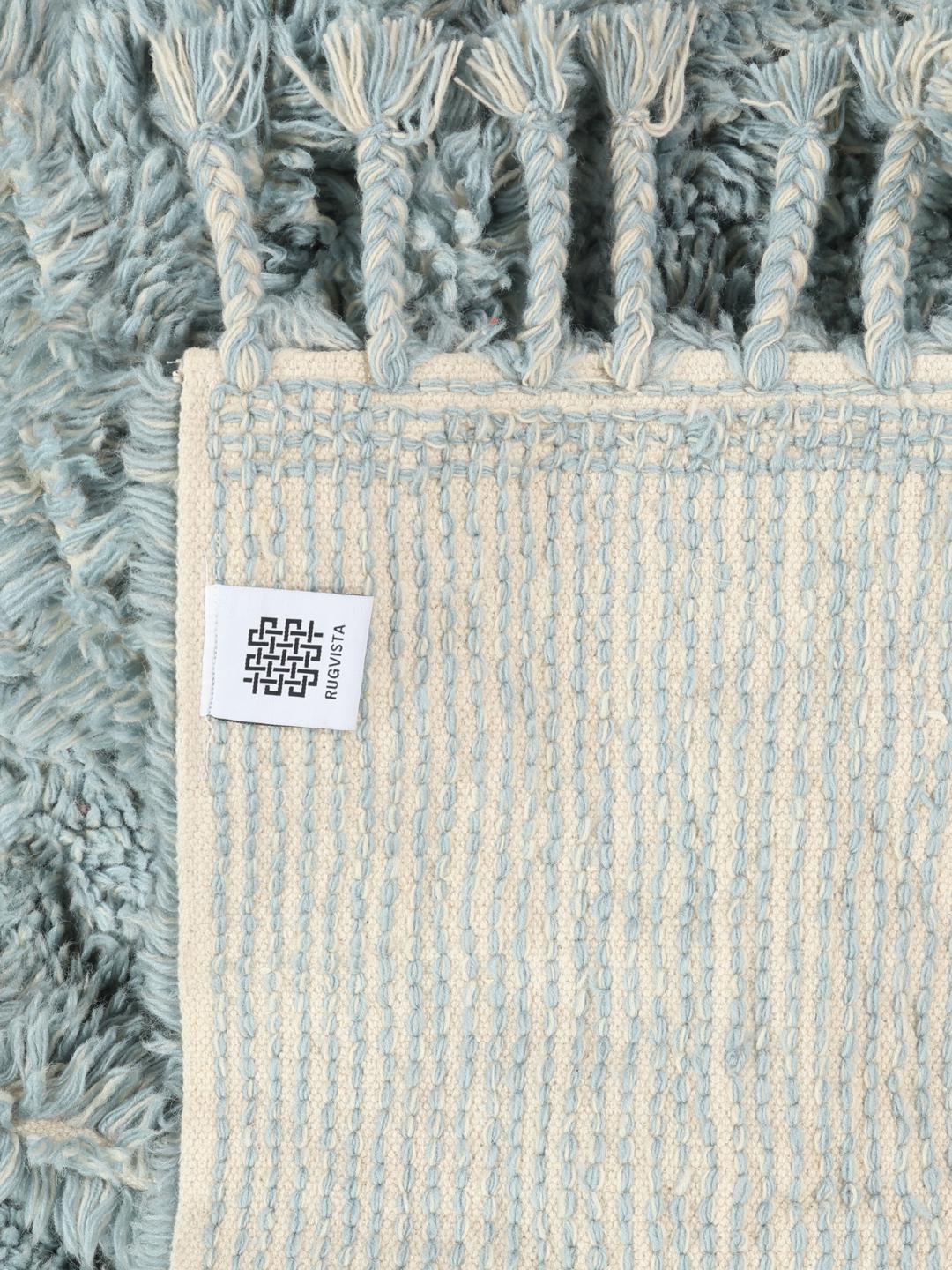 Een pluche blauw shaggy tapijt met franjes.