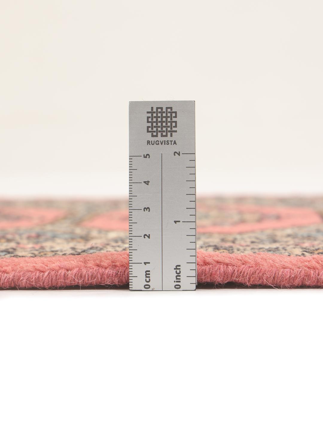 A hand-knotted Pakistan Bokhara rug with a red field and traditional medallion patterns.