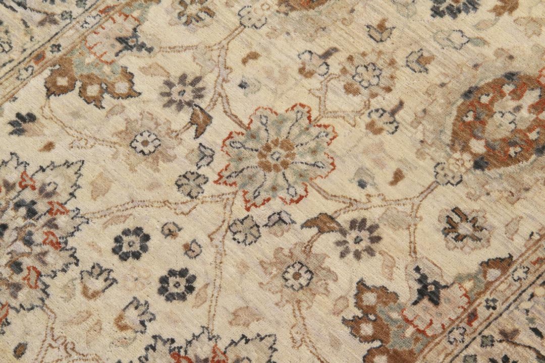 Een klassieke beige handgeknoopte loper uit India met sierlijke bloemmotieven