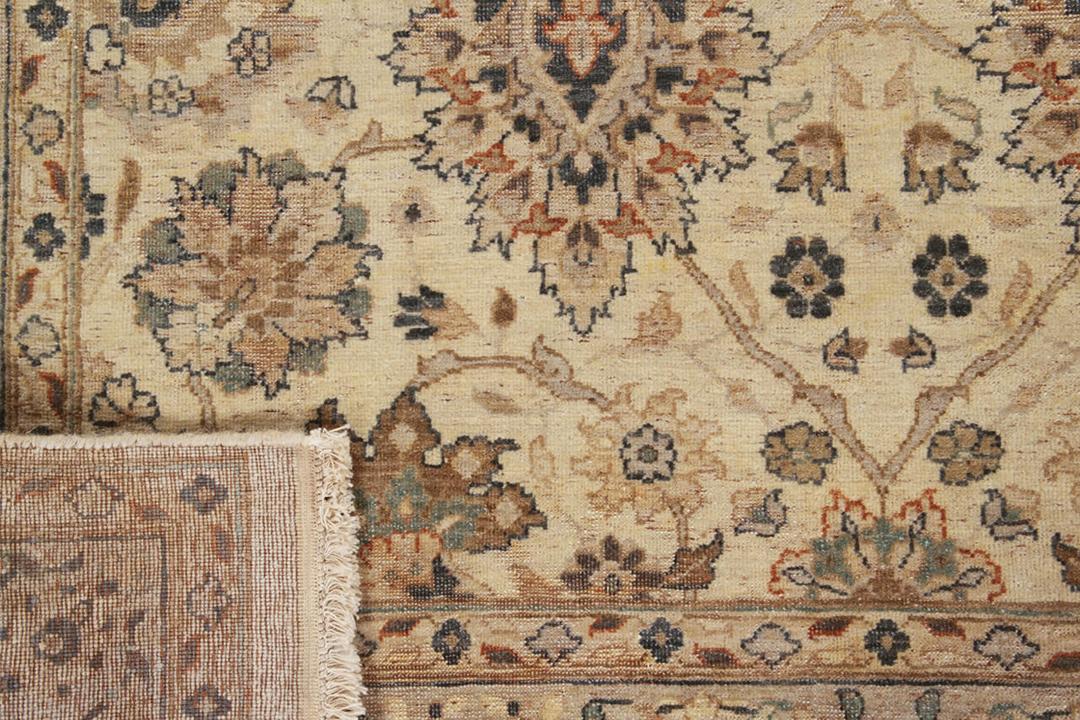 Et håndknyttet indisk tæppe med blomstermotiver i nuancer af beige og blå.