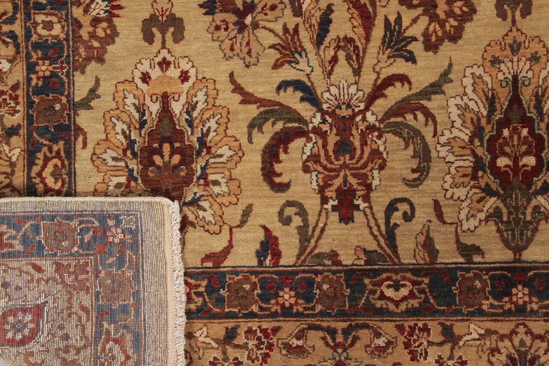 Een handgeknoopt tapijt uit India met een beige achtergrond en klassieke bloemmotieven.