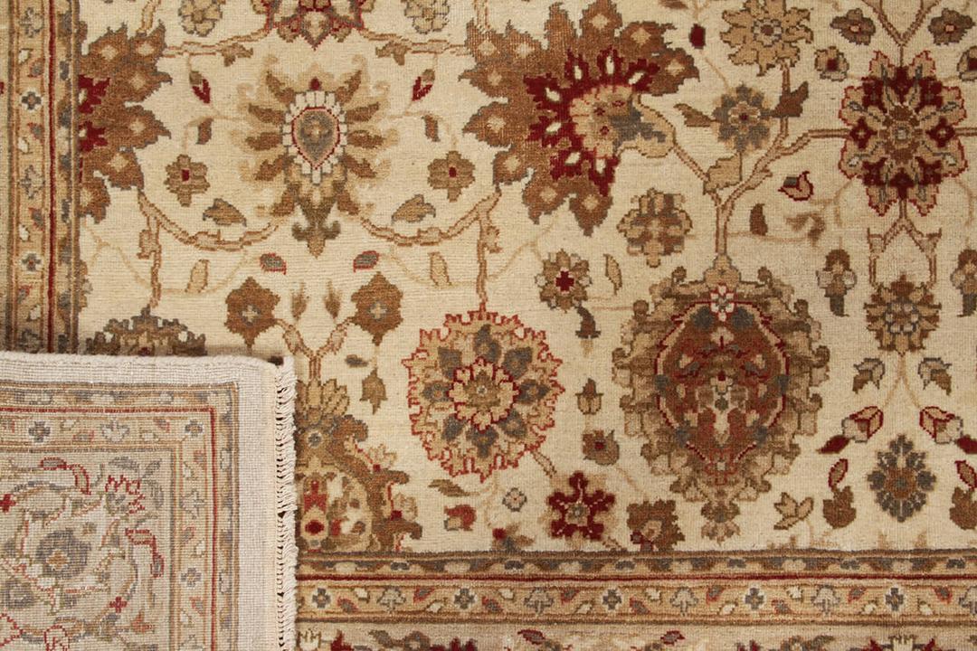 Handgeknoopt Indiaas kleed met een klassiek bloemmotief in beige en rode tinten.