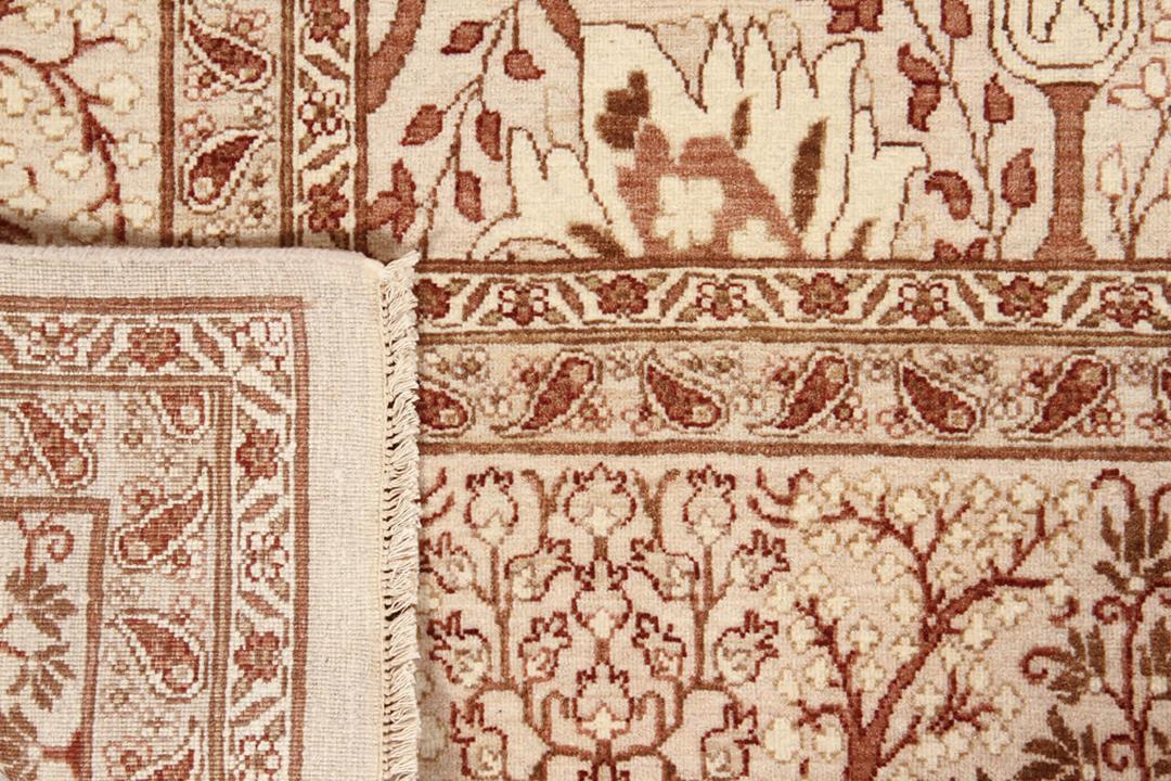 Handgeknoopt Indiaas tapijt met bloemmotieven in beige en rode tinten.