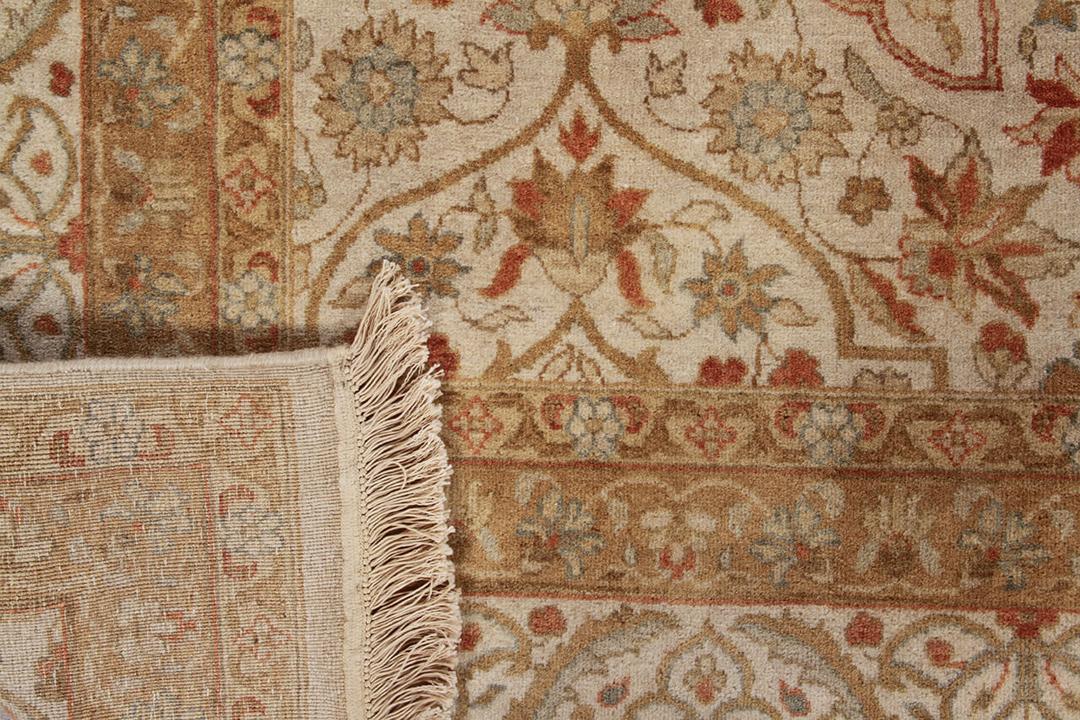 Een handgeknoopt klassiek oosters tapijt uit India met een beige en roestkleurig bloemmotief
