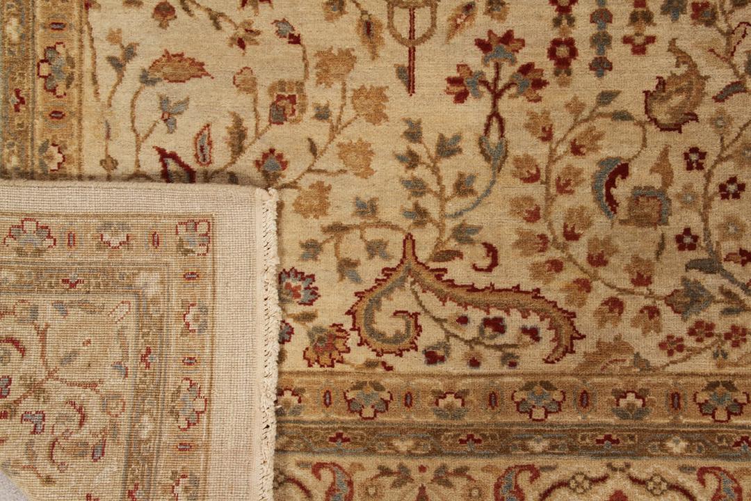 Et håndknyttet beige tæppe fra Indien med et indviklet blomstermønster.