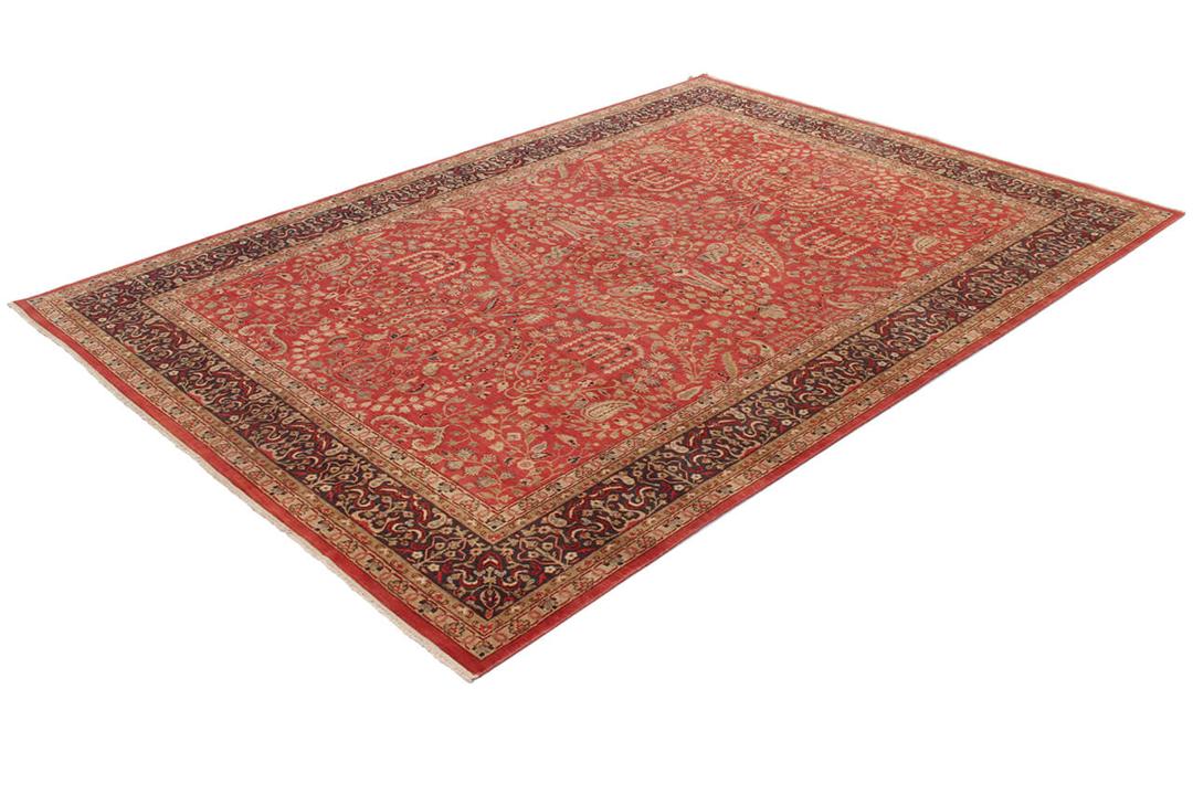 Een handgeknoopt rood Indiaas tapijt met verfijnde bloemmotieven.