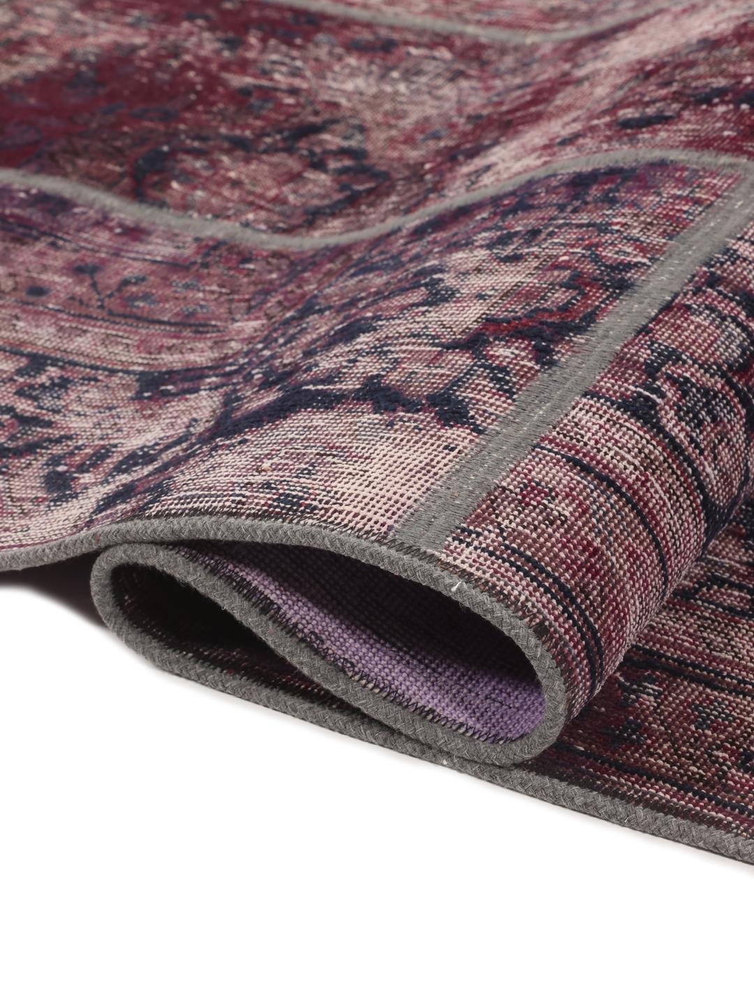 A rectangular patchwork rug from the Middle East featuring a dark-red and dark-blue colour palette.