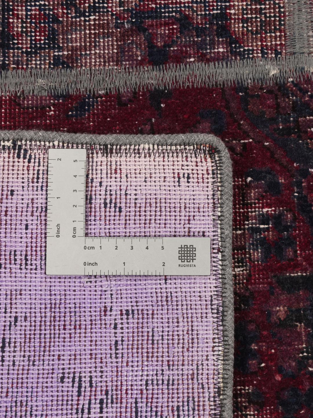 A rectangular patchwork rug from the Middle East featuring a dark-red and dark-blue colour palette.