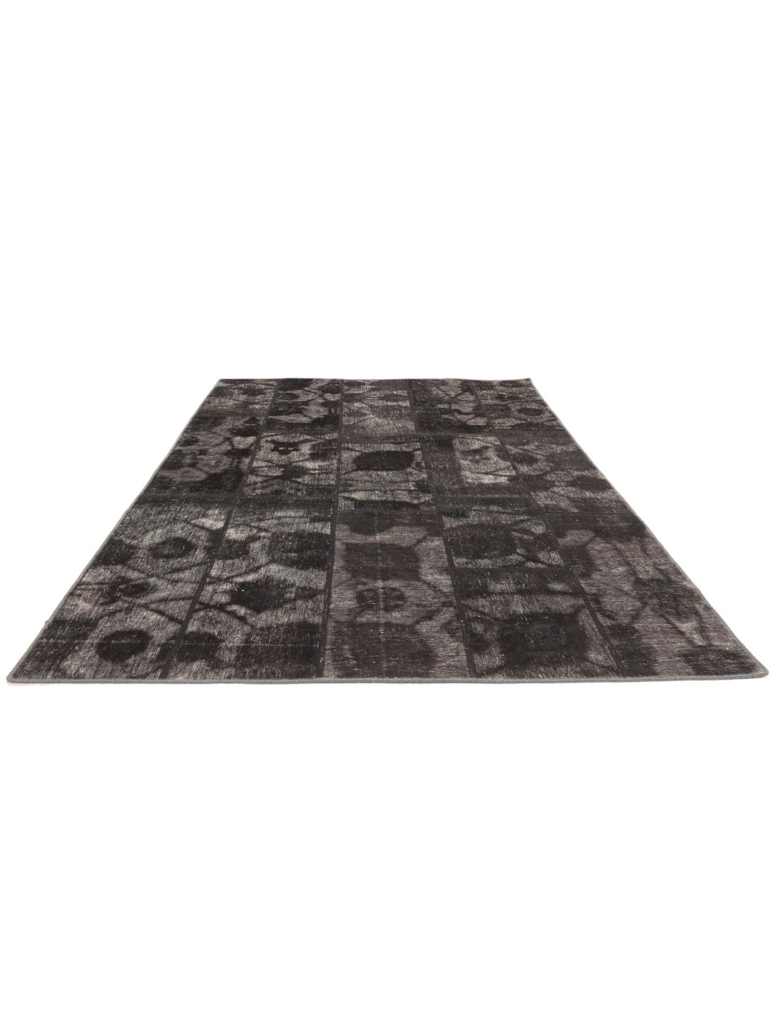 A unique patchwork rug with black and grey tones from the Middle East