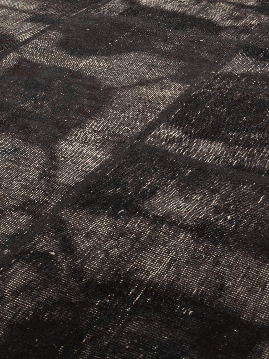 A unique patchwork rug with black and grey tones from the Middle East