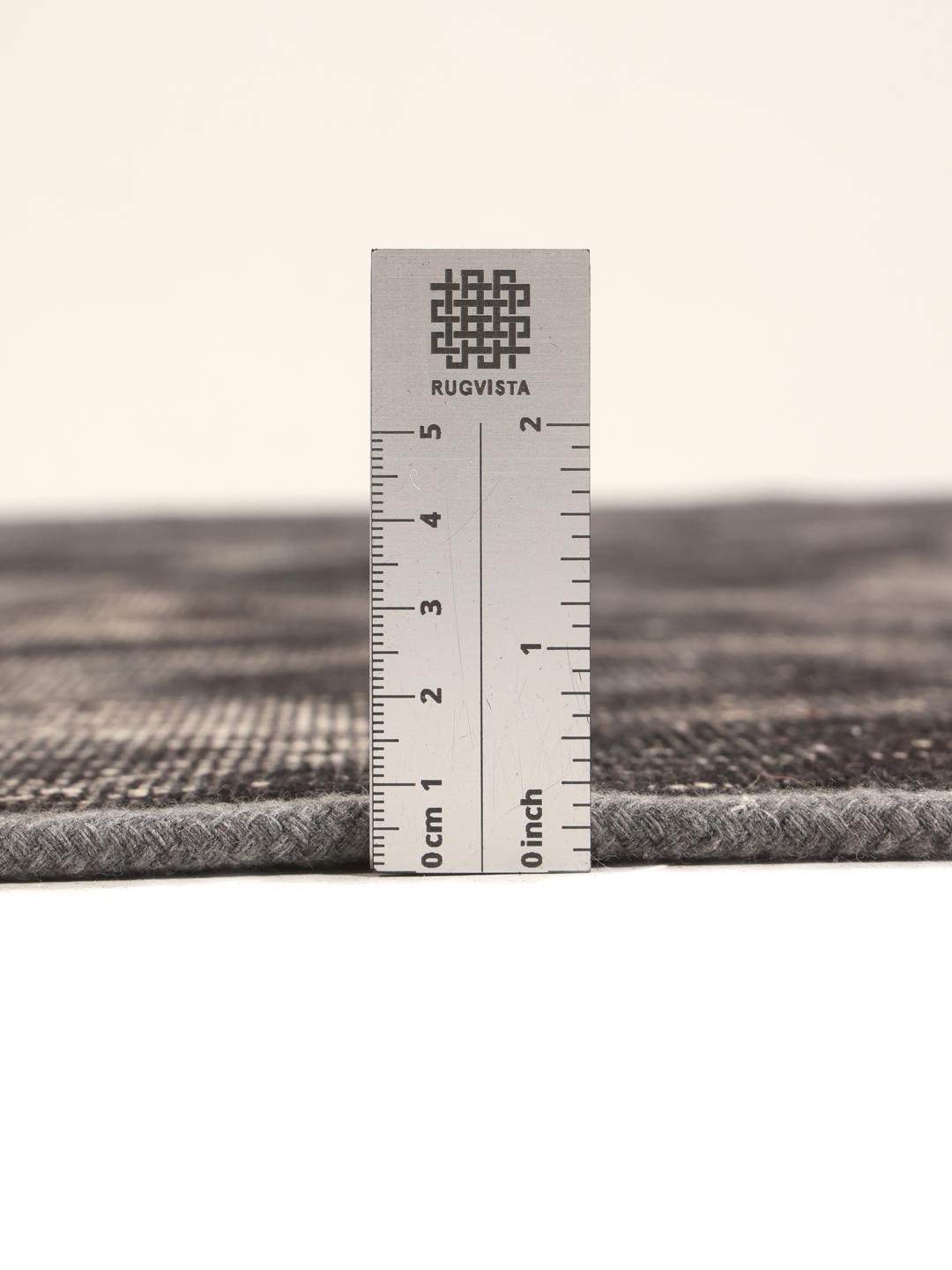 A unique patchwork rug with black and grey tones from the Middle East