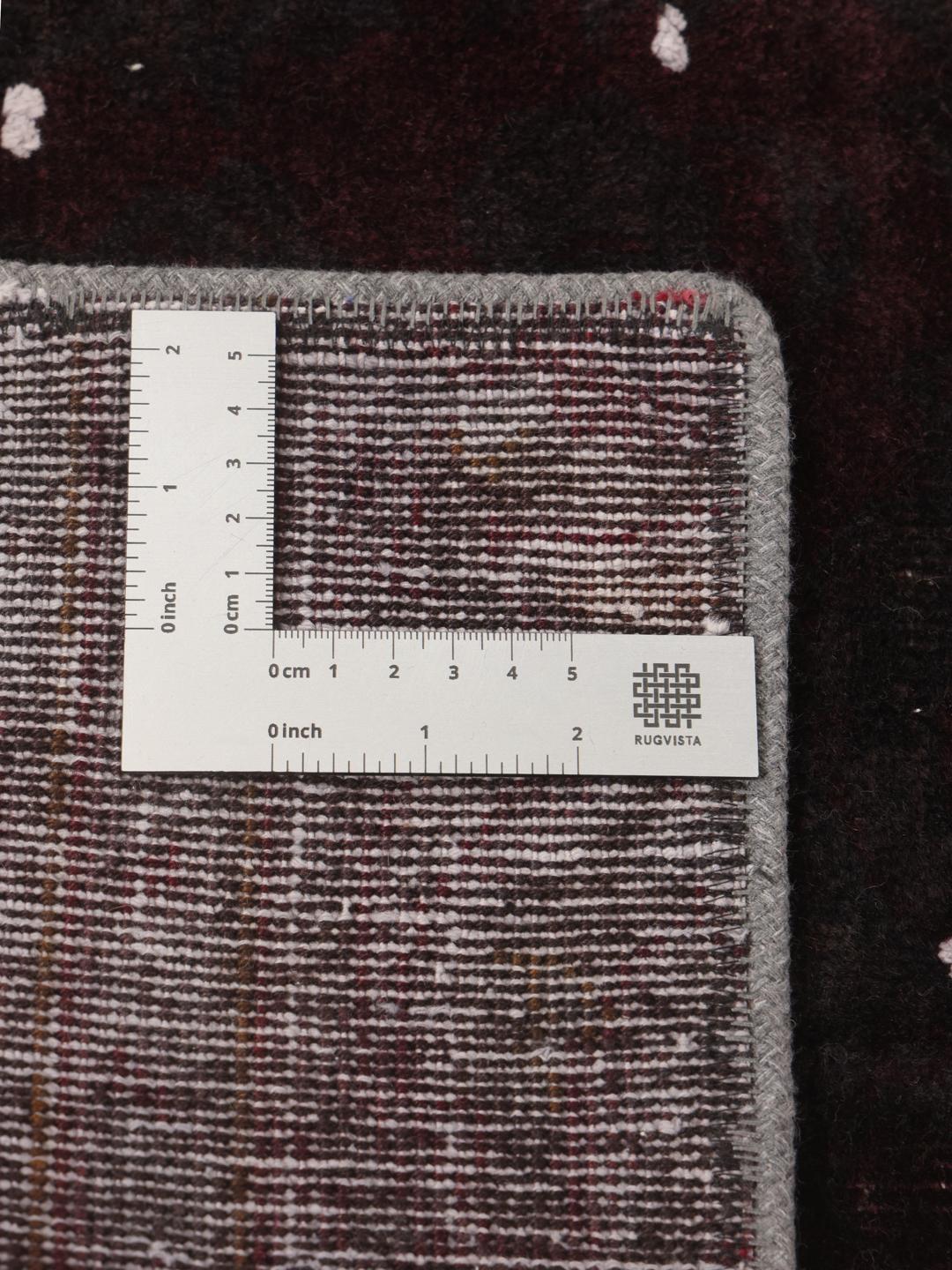 A rectangular patchwork rug from the Middle East in black and dark-grey tones.