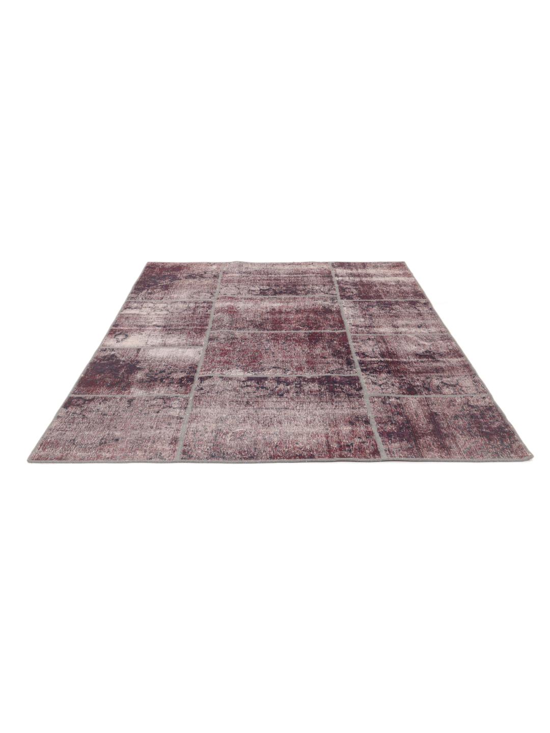 A unique patchwork rug with deep red and dark tones, Middle Eastern origin