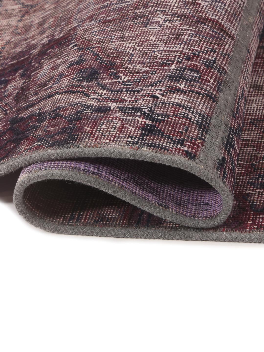 A unique patchwork rug with deep red and dark tones, Middle Eastern origin