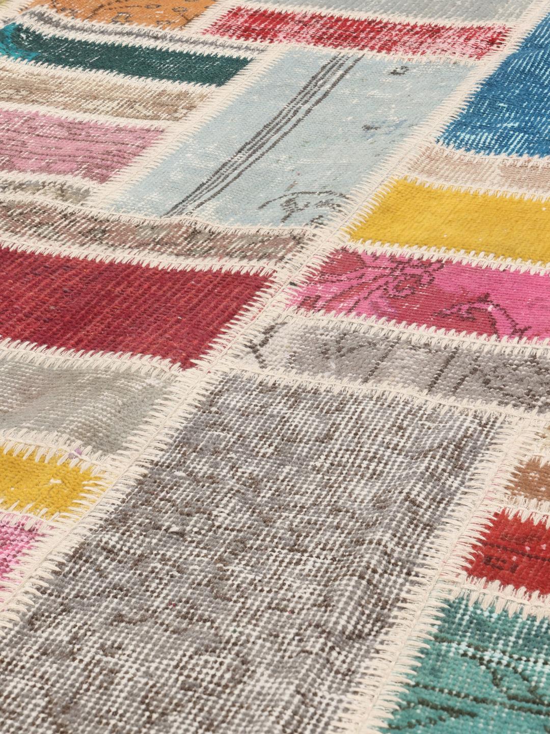 Et levende og unikt patchwork-teppe fra Tyrkia med et flerfarget design.