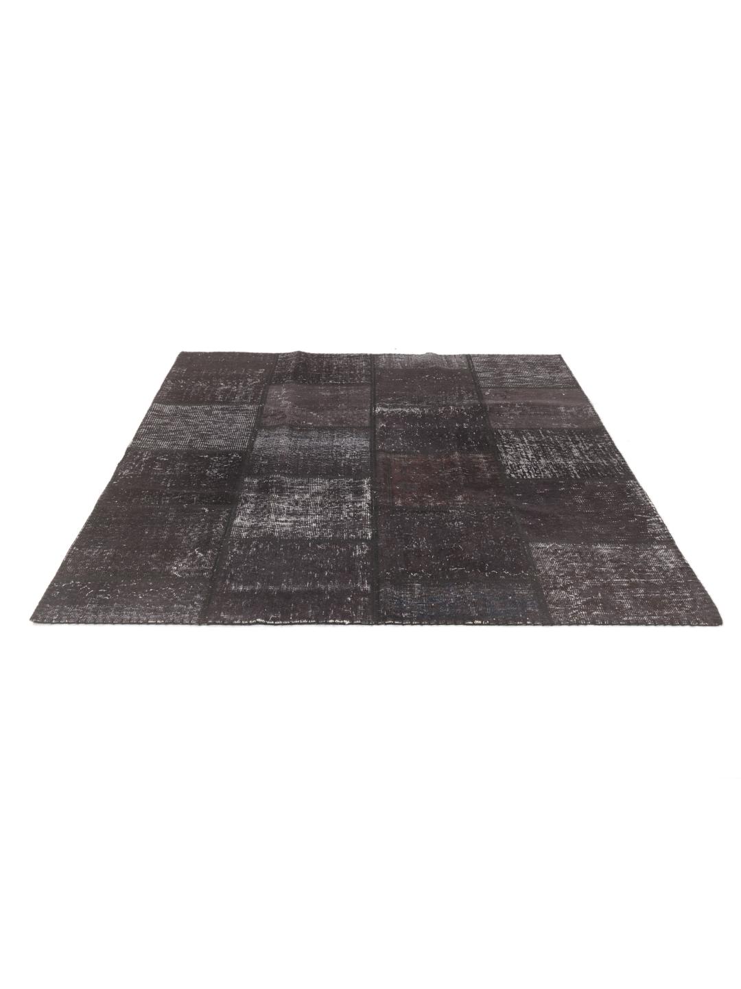 Et unikt patchwork-teppe i mørke nyanser, håndlaget i Tyrkia.