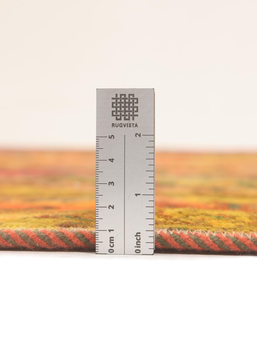 Et flerfarvet patchworktæppe fra Mellemøsten, der viser en række håndknyttede mønstre og varme toner.