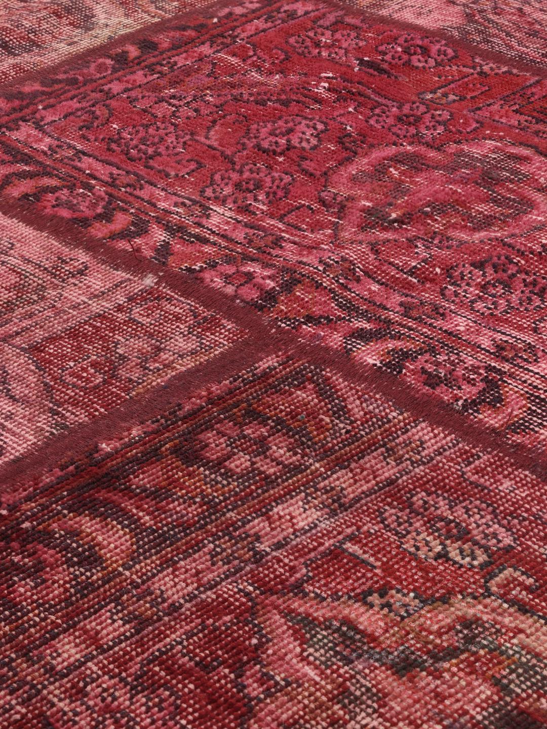 A handcrafted patchwork rug from the Middle East featuring a vibrant dark-red colour palette.