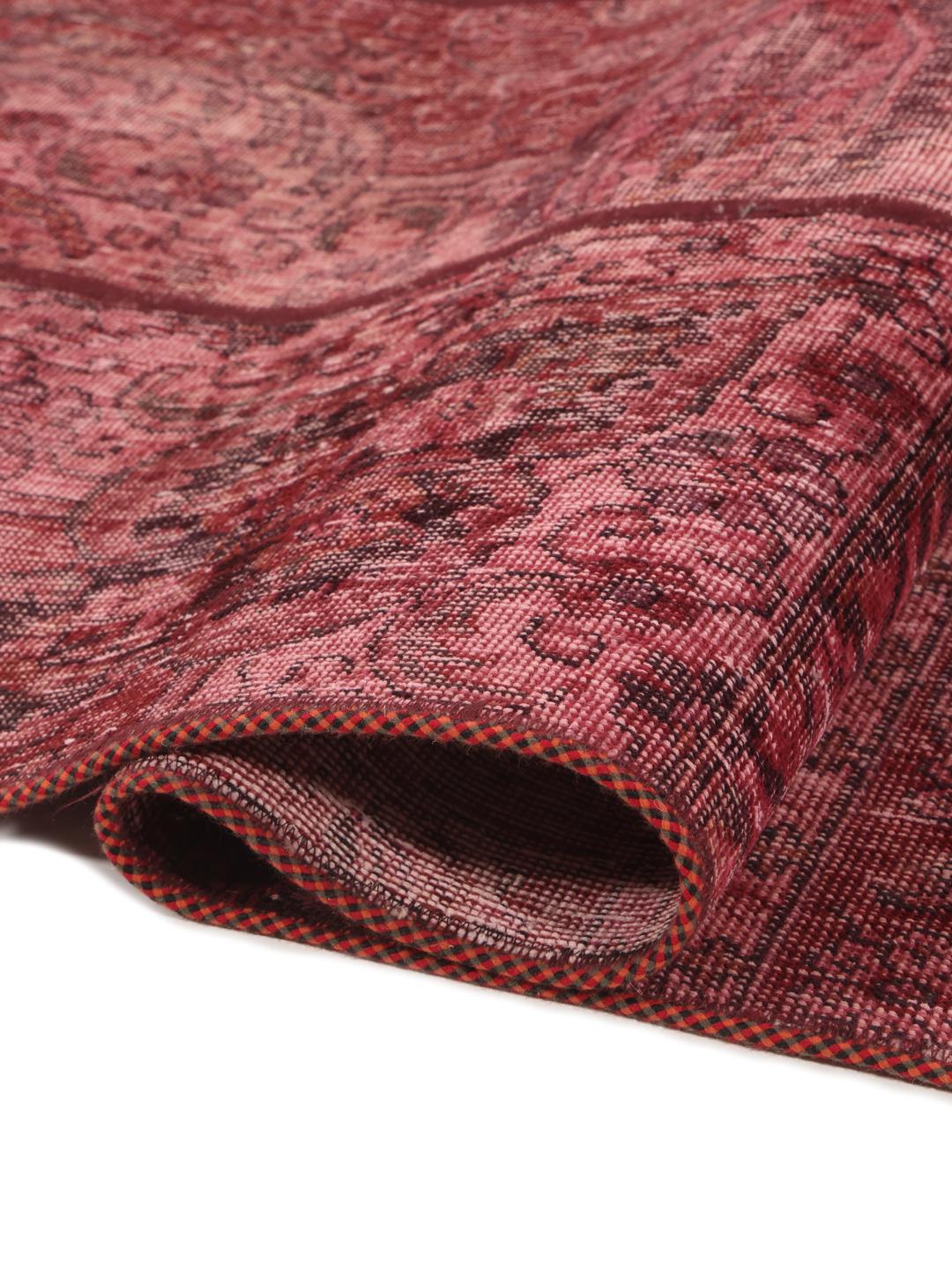 A handcrafted patchwork rug from the Middle East featuring a vibrant dark-red colour palette.