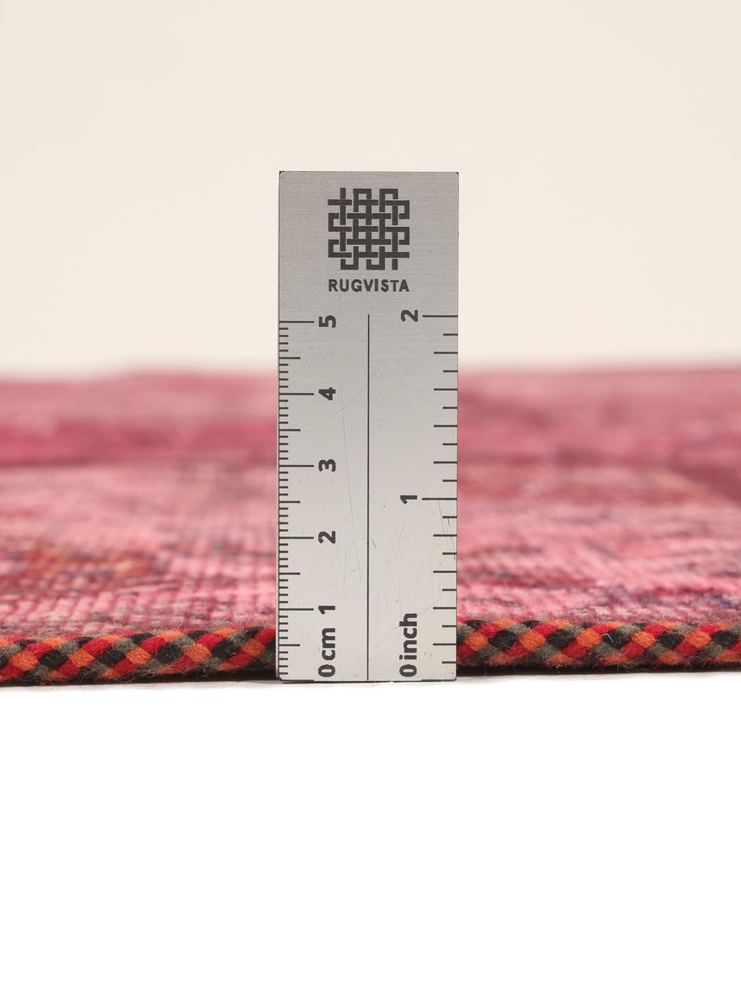 A handcrafted patchwork rug from the Middle East featuring a vibrant dark-red colour palette.