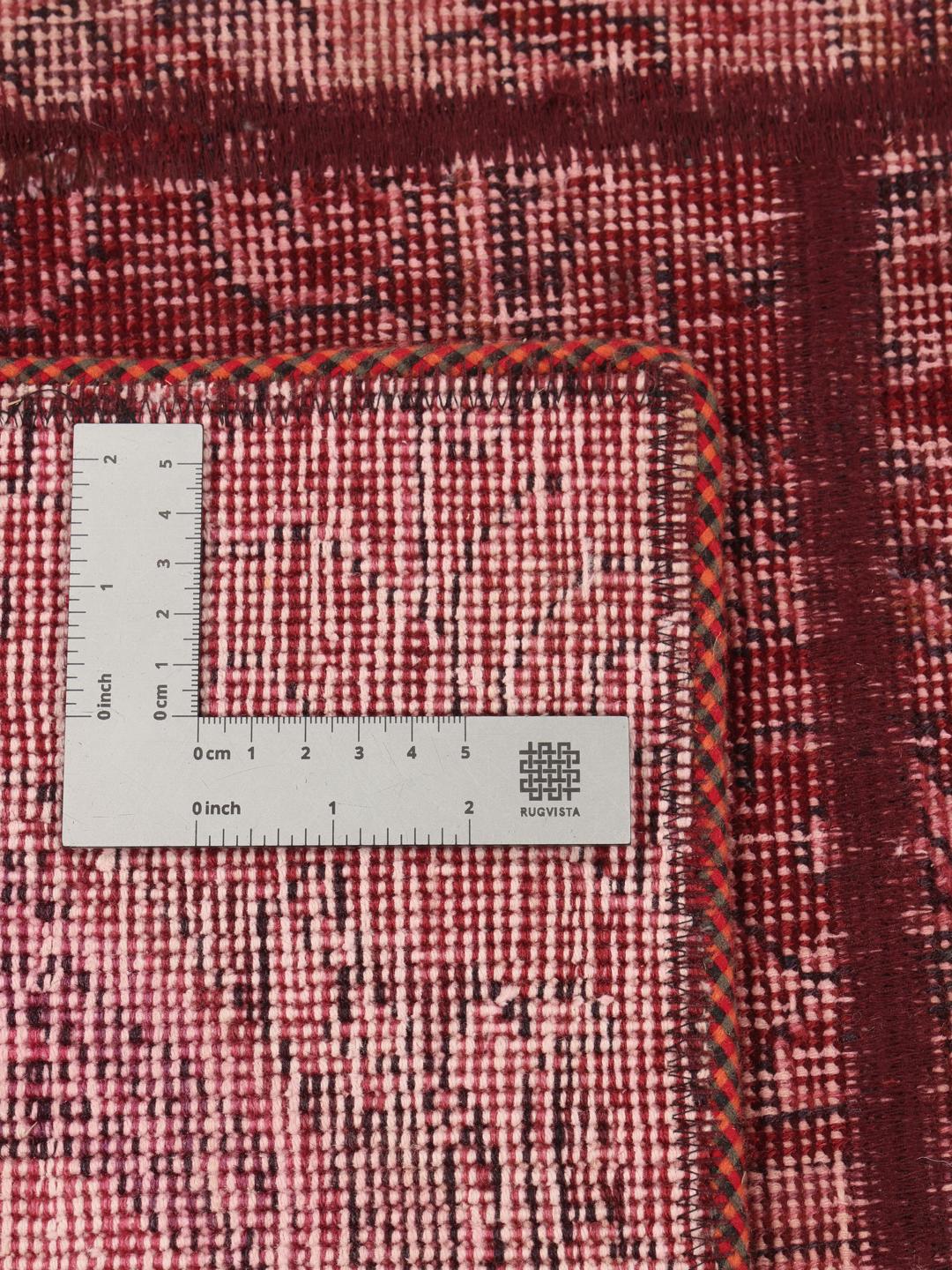 A handcrafted patchwork rug from the Middle East featuring a vibrant dark-red colour palette.