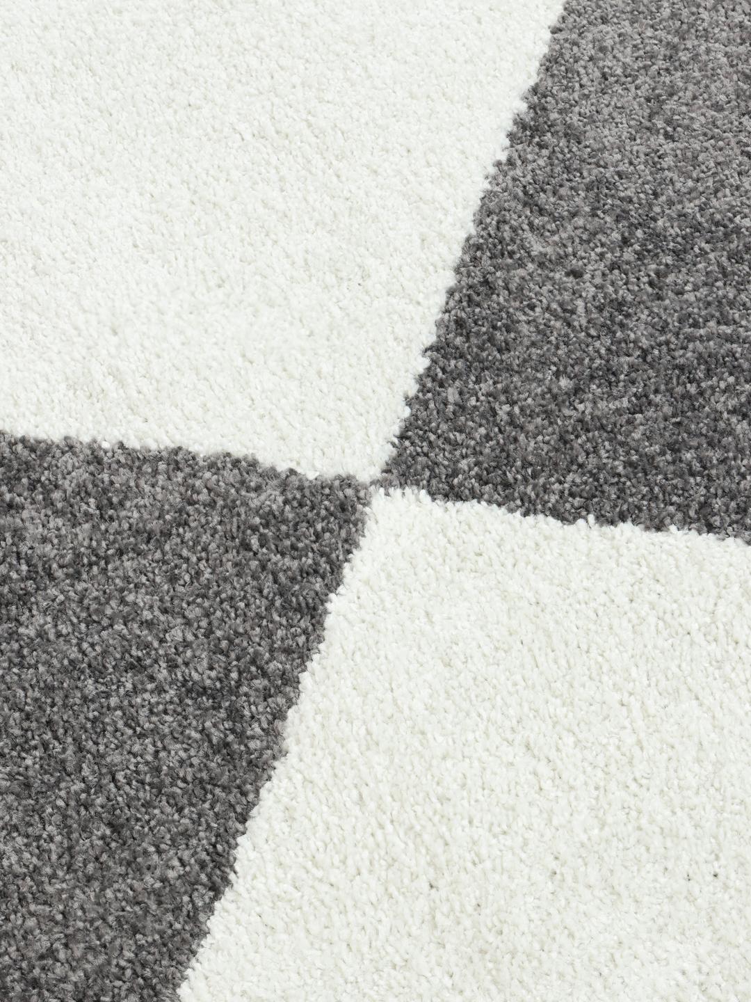 Tapis blanc et gris avec un motif de losanges