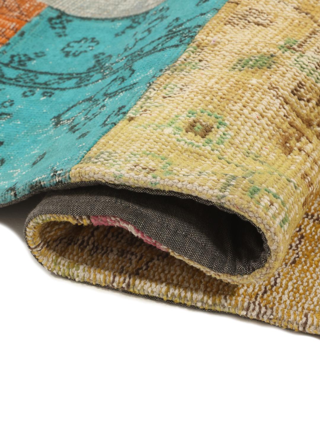 Een groot, levendig, rechthoekig patchwork tapijt uit Turkije met een veelkleurige pool van wol.