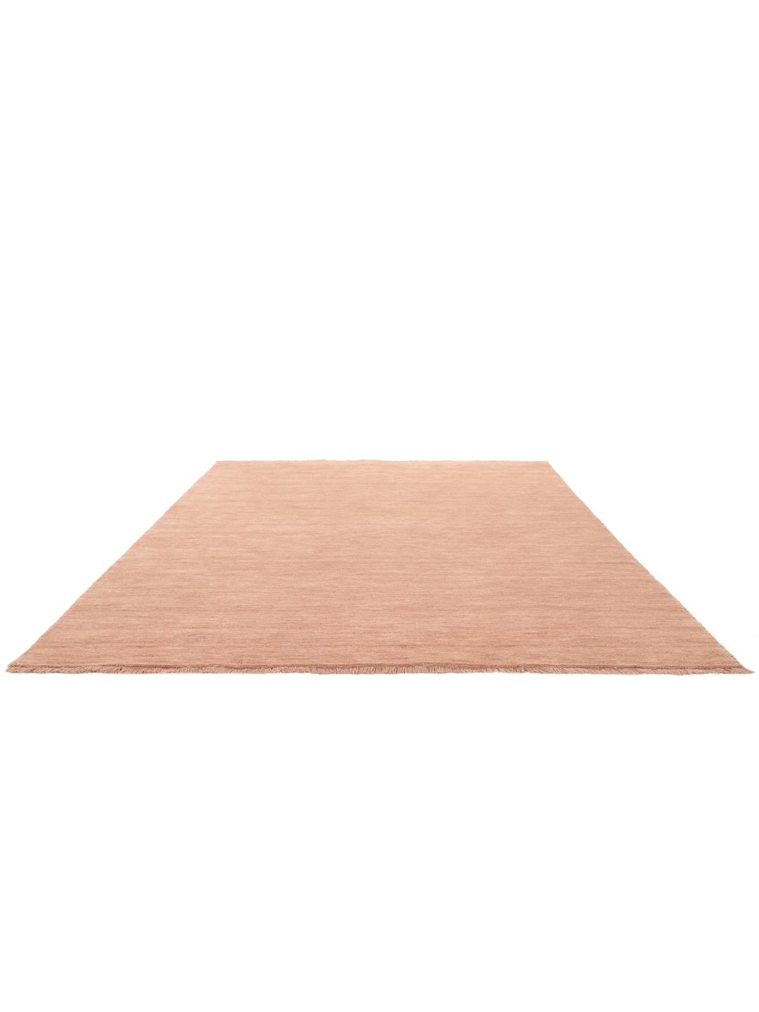 Een eenkleurig roze handgeweven poolvloerkleed met korte franjes