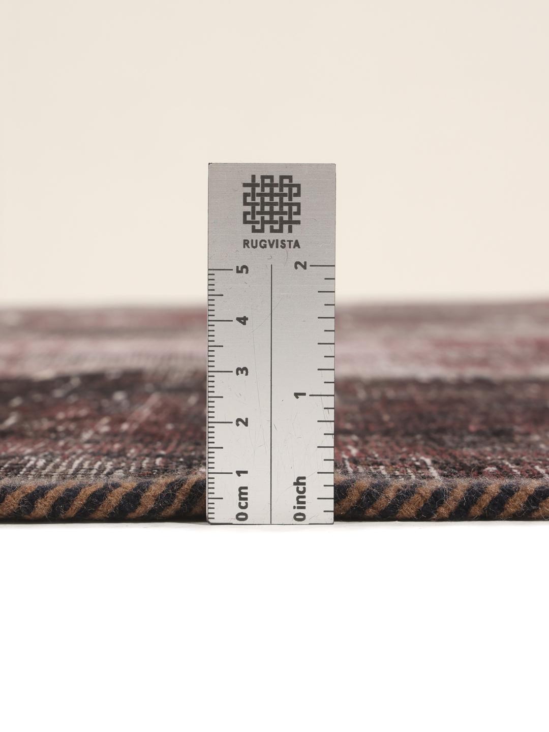 A rectangular patchwork rug featuring vertical stripes in dark-grey and deep red tones, of Middle Eastern origin.