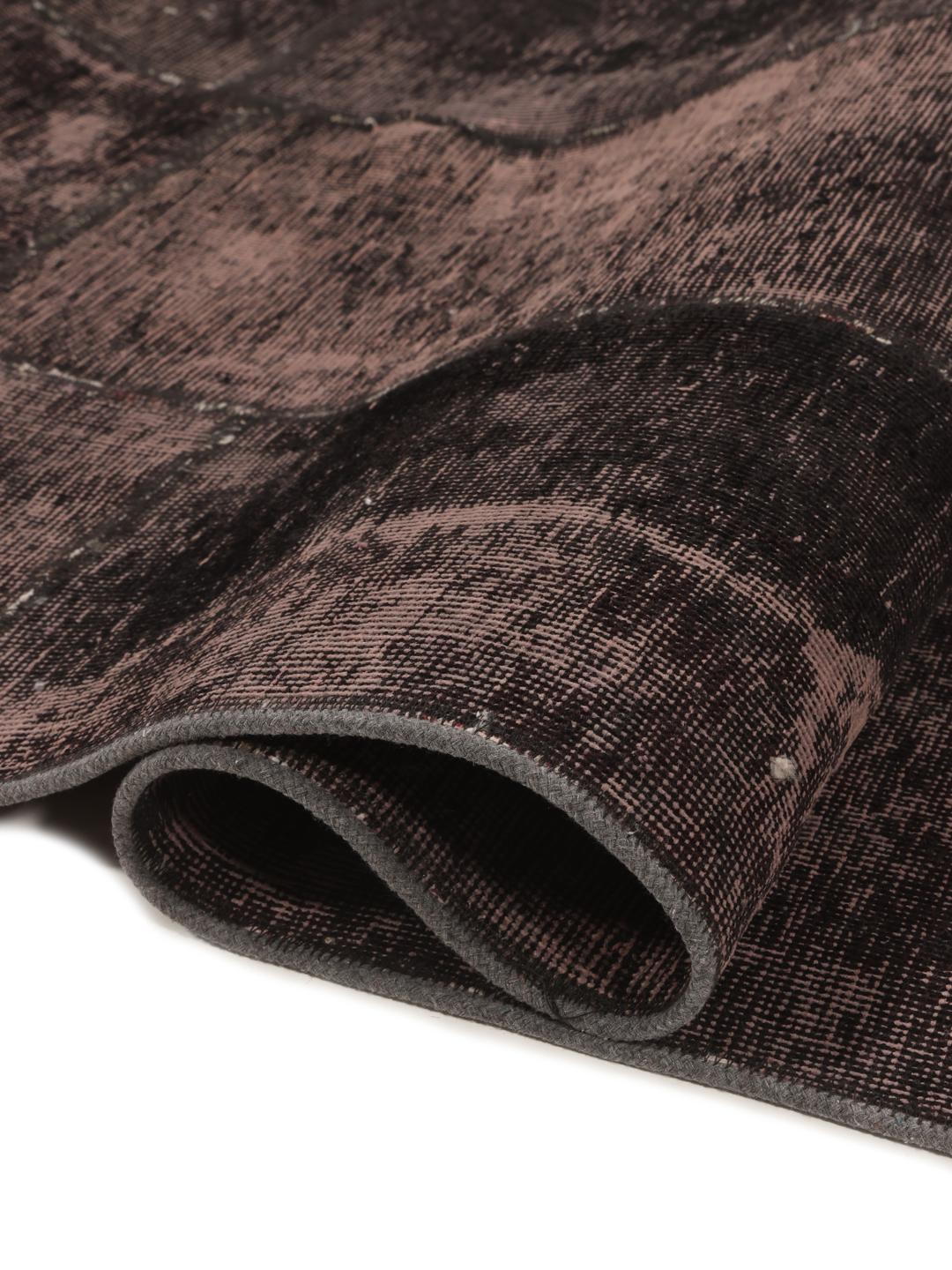En lang, mørkegrå patchwork-løber med et ornamentalt, falmet mønster.