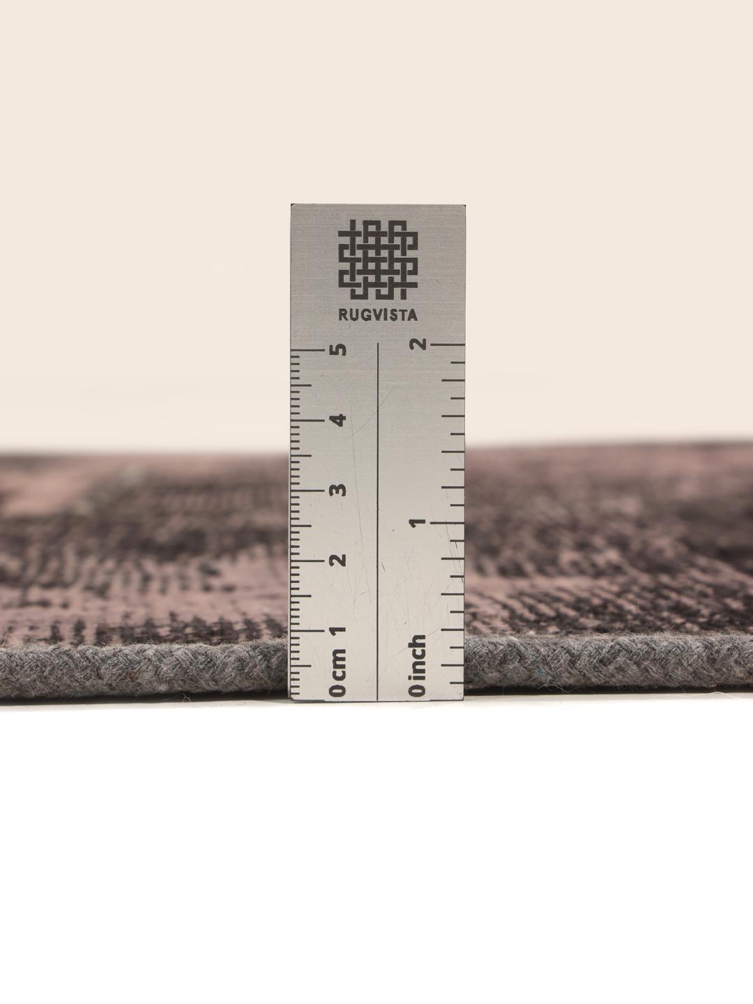 En lang, mørkegrå patchwork-løber med et ornamentalt, falmet mønster.