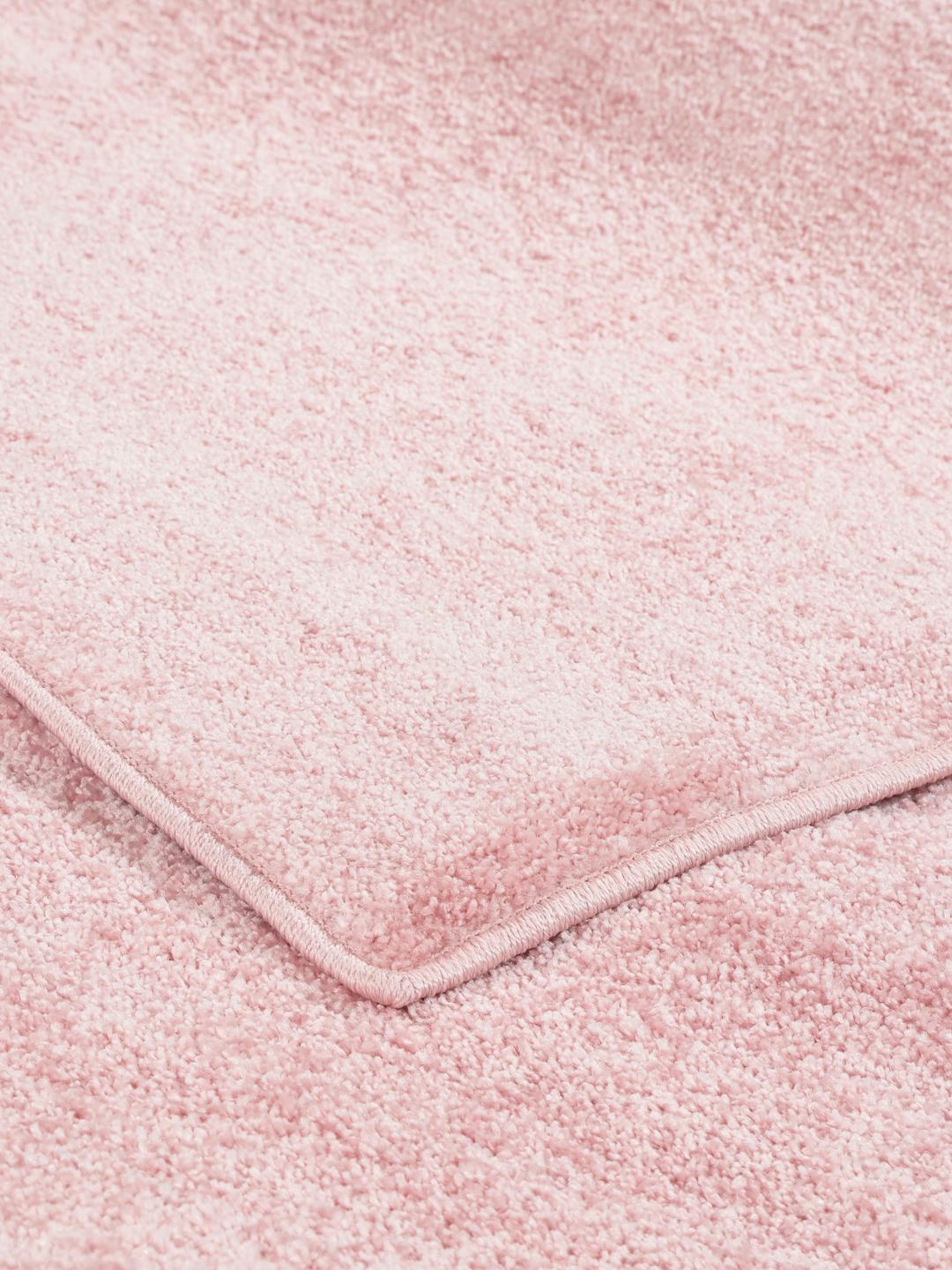 Um tapete cor-de-rosa claro sólido com uma textura suave.