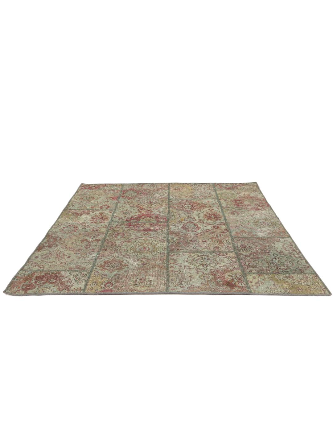 Et kvadratisk, flerfarget patchwork-teppe laget av vintage-fragmenter.