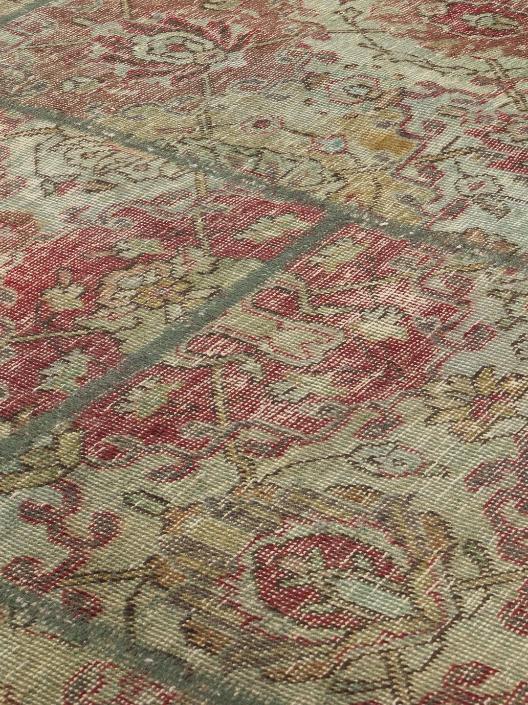 Et kvadratisk, flerfarget patchwork-teppe laget av vintage-fragmenter.