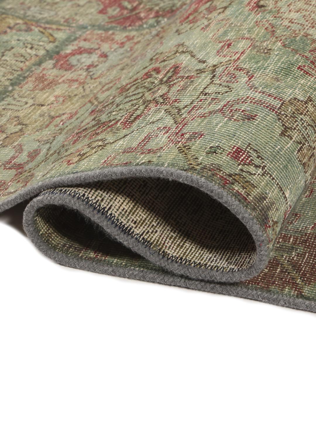 Et kvadratisk, flerfarget patchwork-teppe laget av vintage-fragmenter.