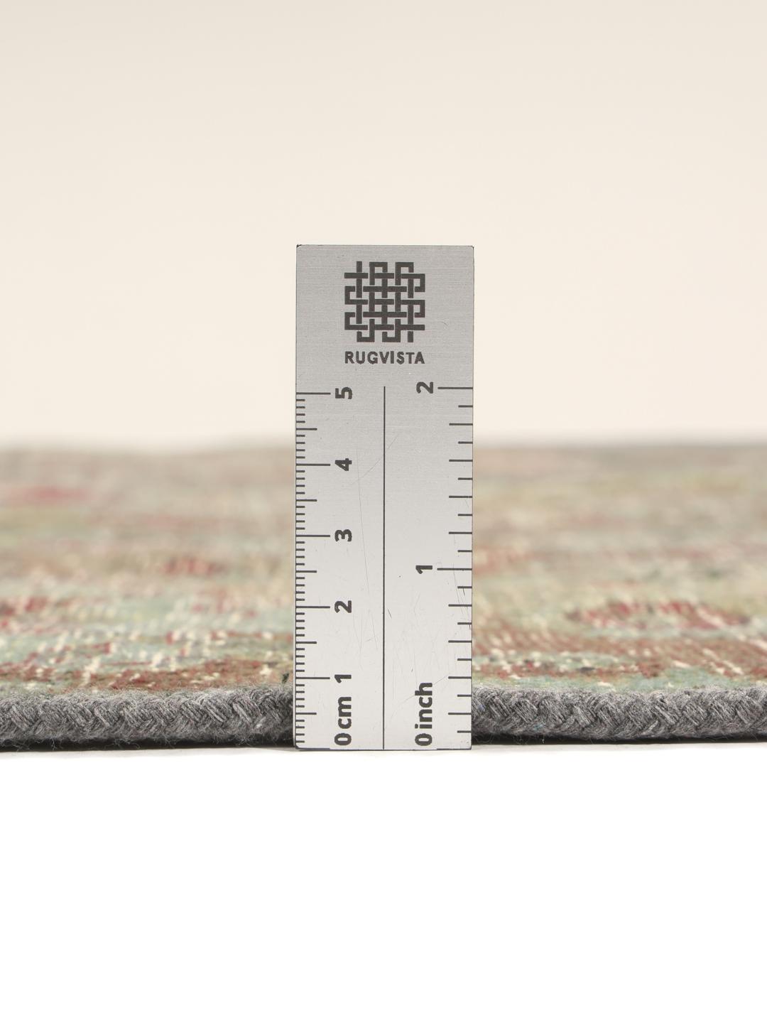 Et kvadratisk, flerfarget patchwork-teppe laget av vintage-fragmenter.