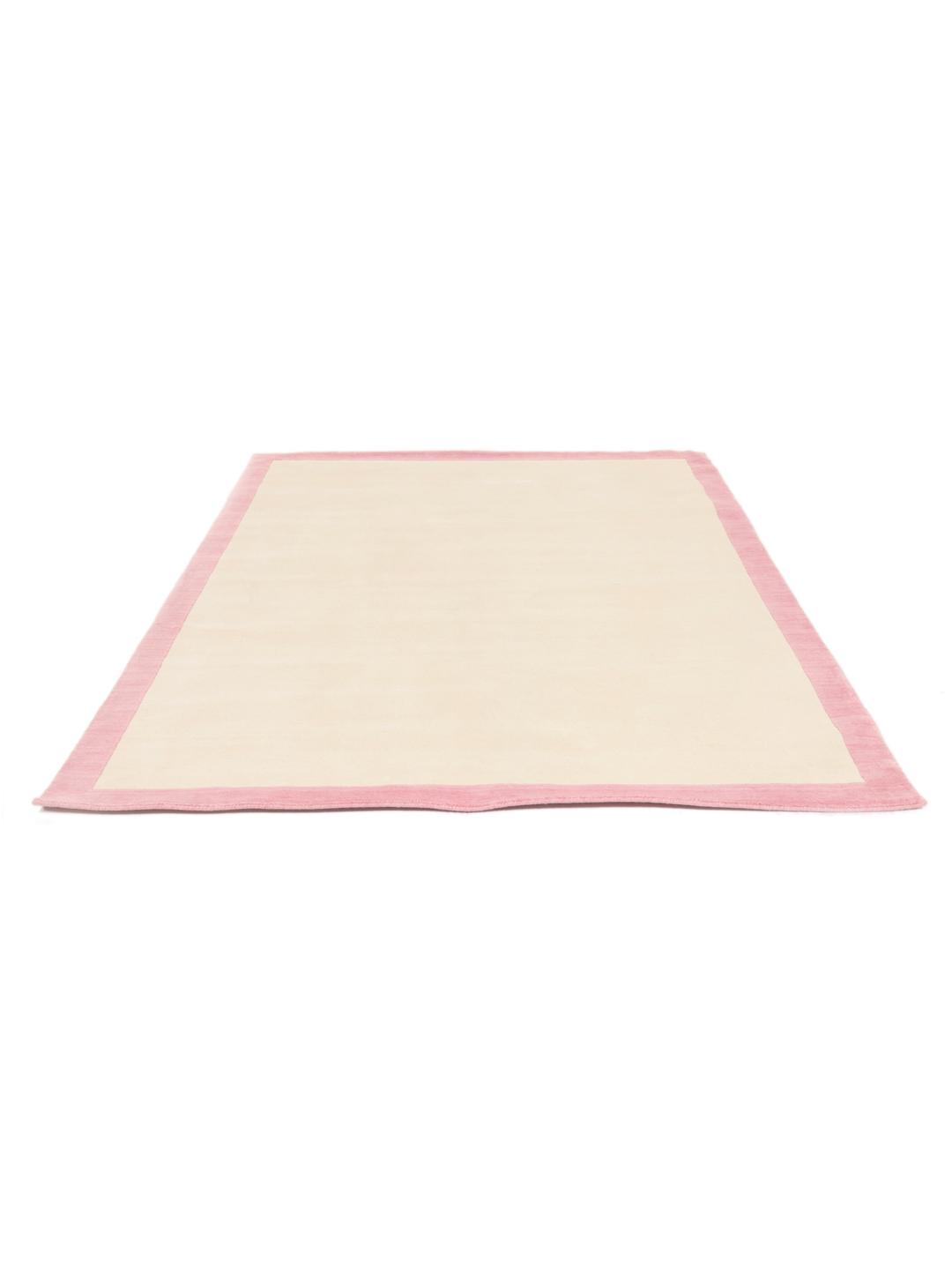 Et minimalistisk håndvævet tæppe fra Indien med beige center og pink kant