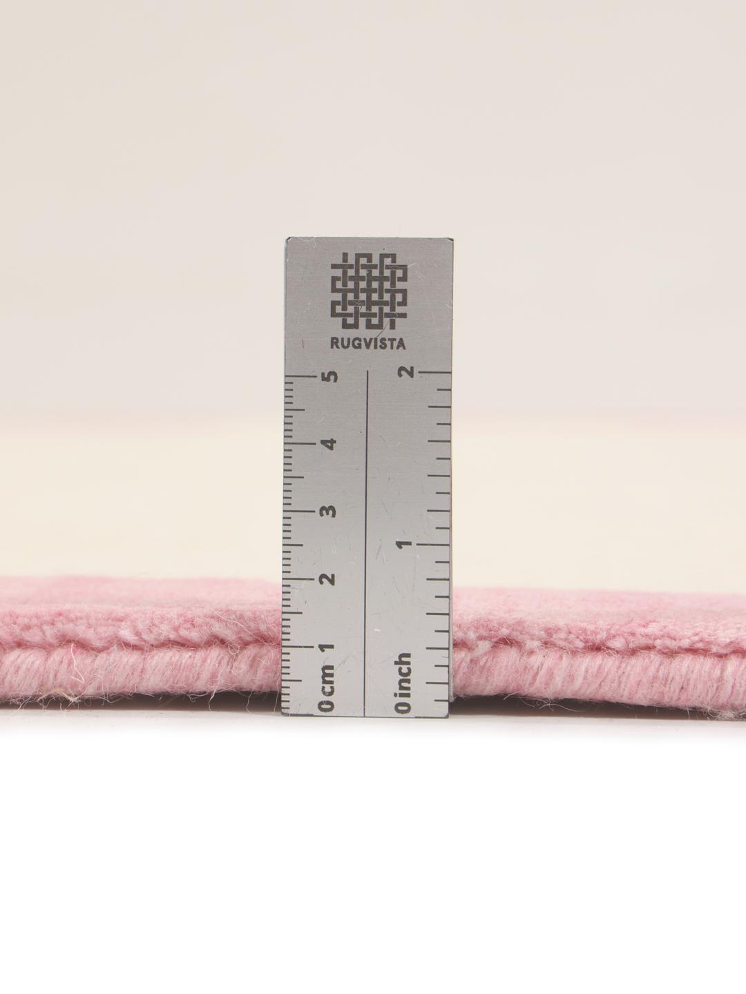 Et minimalistisk håndvævet tæppe fra Indien med beige center og pink kant