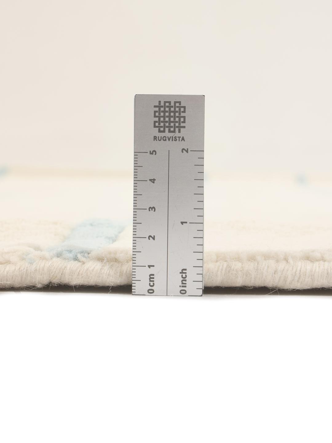 Een rond, beige handgeweven tapijt uit India met lichtblauwe horizontale strepen.