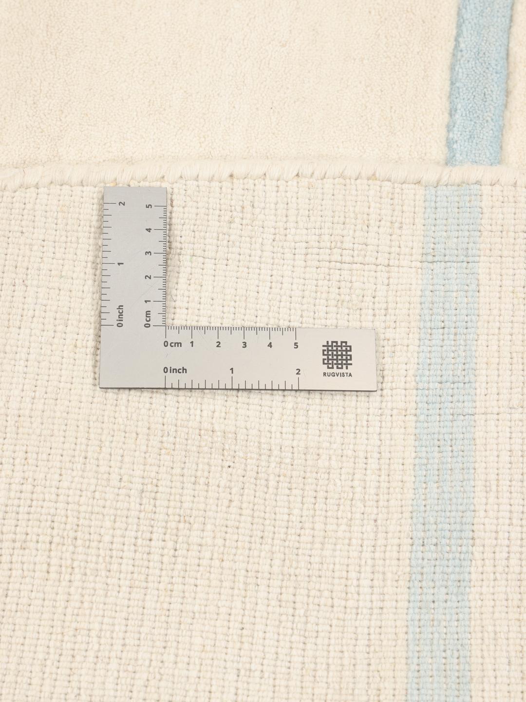 Een rond, beige handgeweven tapijt uit India met lichtblauwe horizontale strepen.