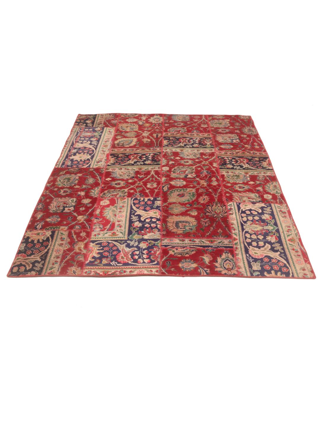 Een levendig rechthoekig patchwork tapijt met ingewikkelde patronen uit het Midden-Oosten in rode en blauwe tinten.